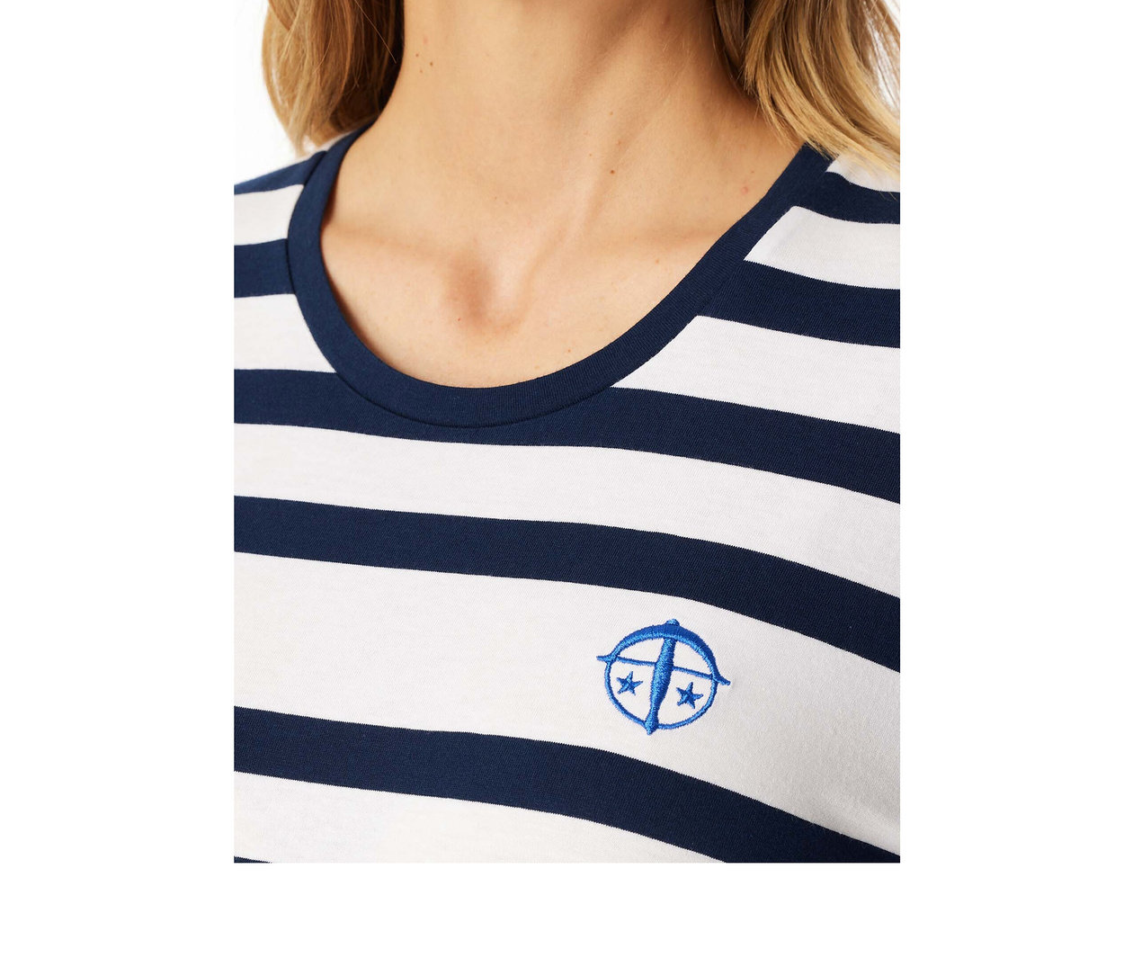 Nahaufnahme einer Frau in einem marineblau-weiß gestreiften SCHIESSER Pyjama-Set mit blauem Sticklogo auf der Brust.