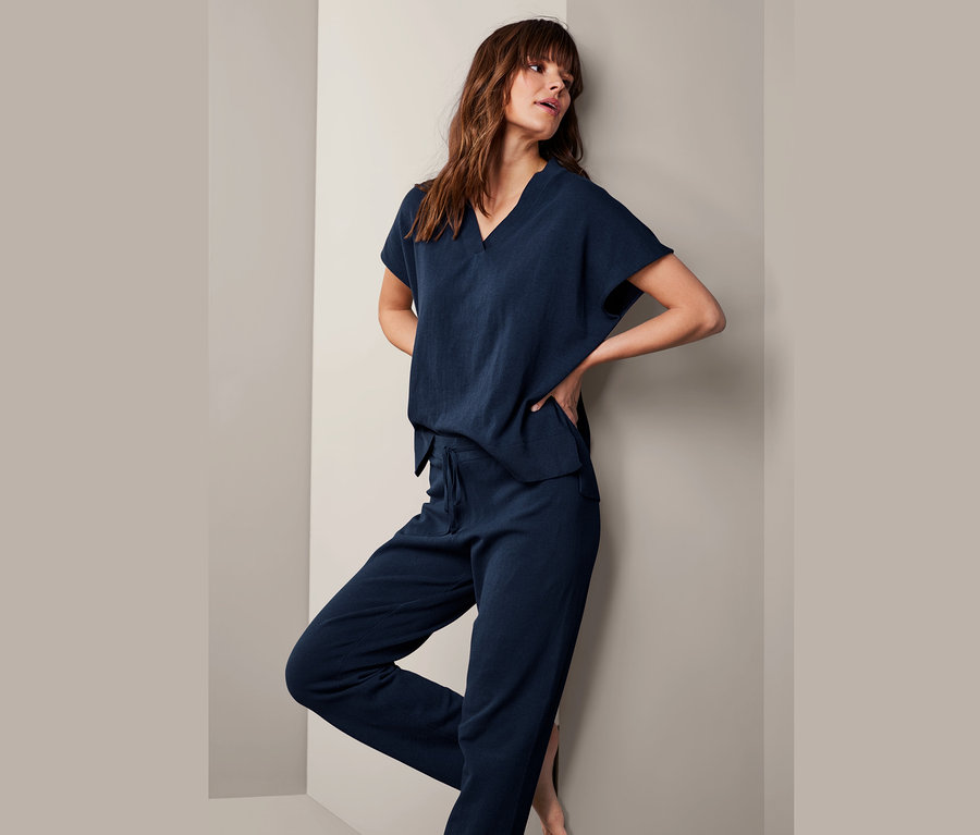 Frau posiert in Feinstrick-Loungewear-Sweatshirt und Hose.