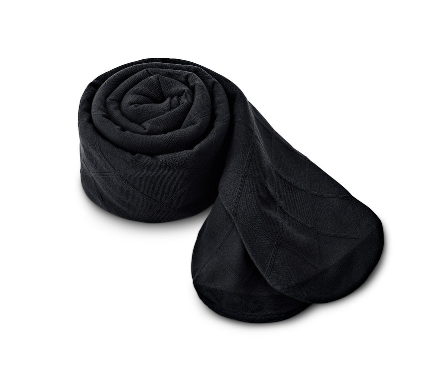 Eine aufgerollte, schwarze Trendstrumpfhose mit Karomuster auf weißem Hintergrund.