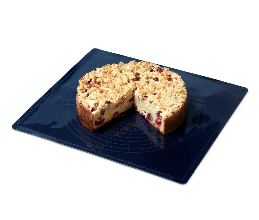 Angeschnittener Streuselkuchen auf blauer Dauerbackmatte.