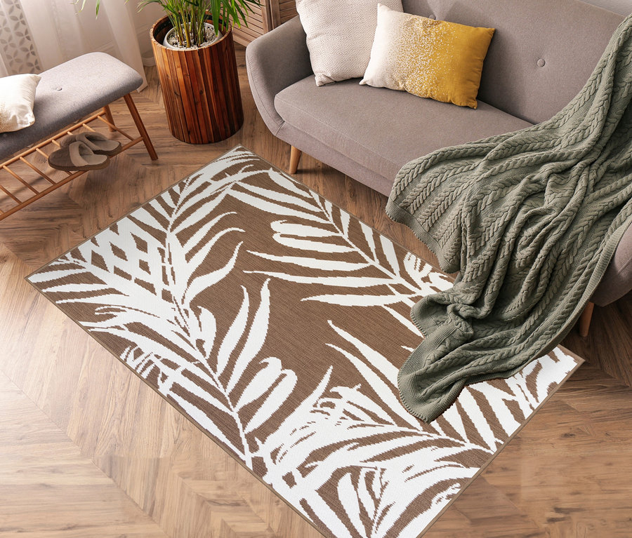 Ein brauner Outdoor-Wende-Teppich »Palm Tree« liegt im Wohnzimmer.
