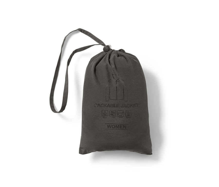 Eine verpackte, leichte Funktionsjacke in einem grauen Beutel mit Kordelzug.