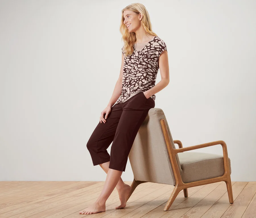 Blonde Frau sitzt auf Sessel in Pyjama mit Spitze.