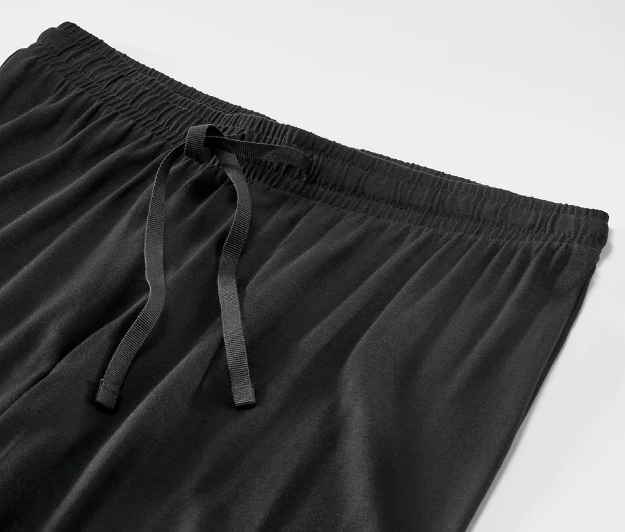 Detailaufnahme einer schwarzen Pyjamahose mit Kordelzug.
