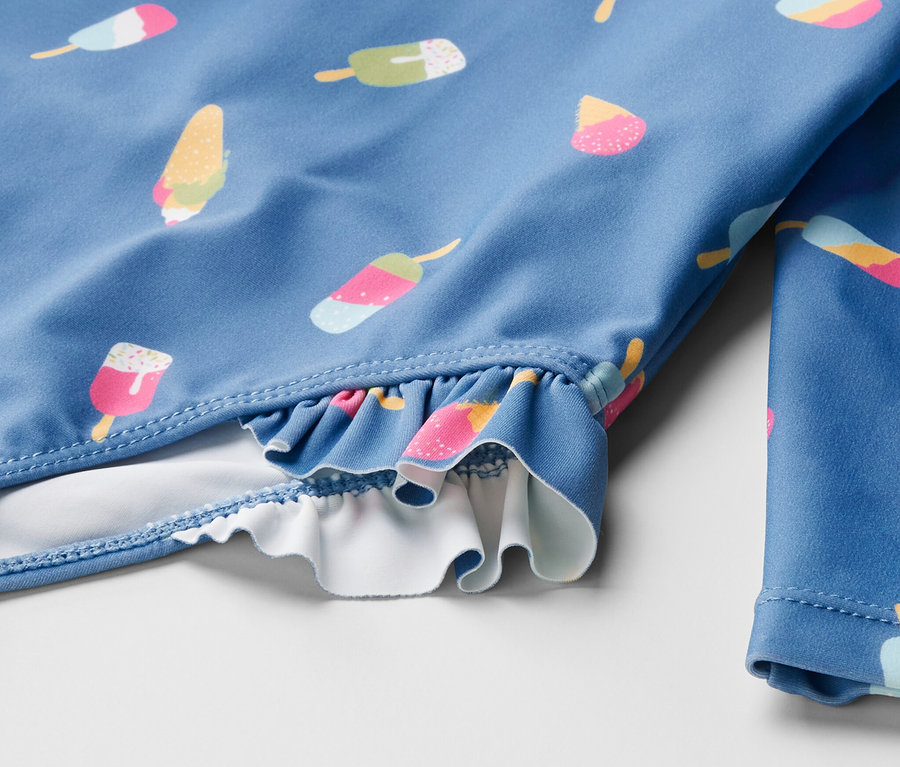 Detailansicht eines blauen Kinder-Badeanzugs mit Eiscreme-Muster und UV-Schutzfaktor 80.