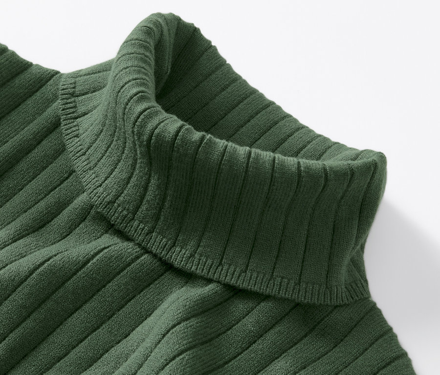 Detailansicht eines grünen, gerippten Rollkragenpullovers.