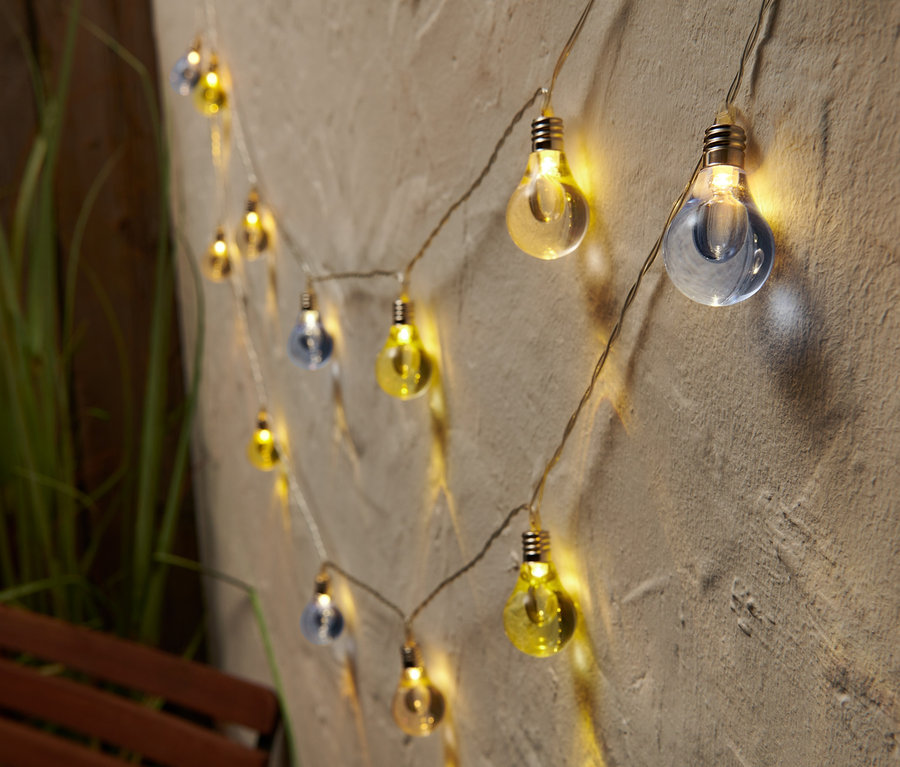 LED-Lichterkette mit blau und gelb gefärbten Glühbirnen an einer Wand.