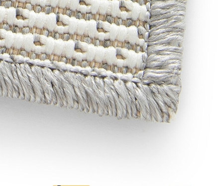 Detailansicht eines grauen, faltbaren Outdoor-Teppichs im geometrischen Design.