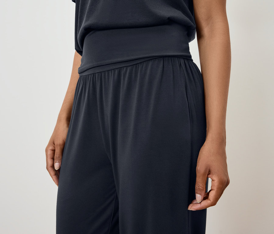 Frau trägt einen schwarzen Pyjama.