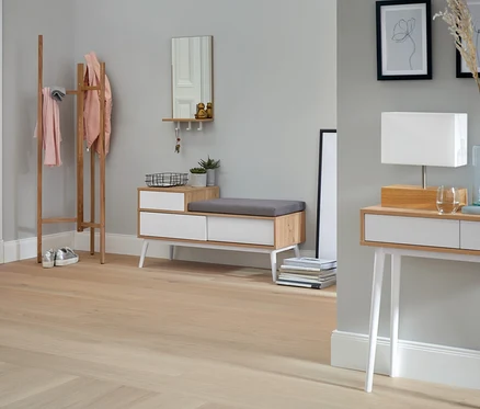 Eingangsbereich mit Sitzbank mit Schuhfach, Spiegel mit Ablage und Haken, Holzgarderobe und Tischleuchte mit Holzfuß.