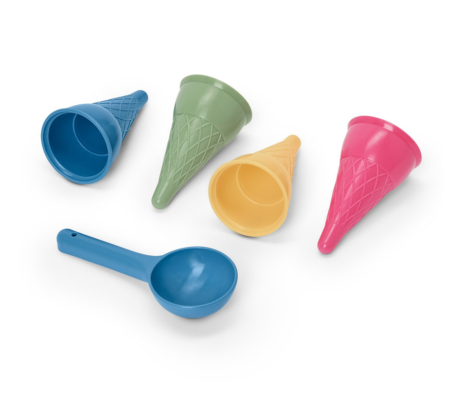 Vier Eis-Sandformen und eine blaue Schaufel.