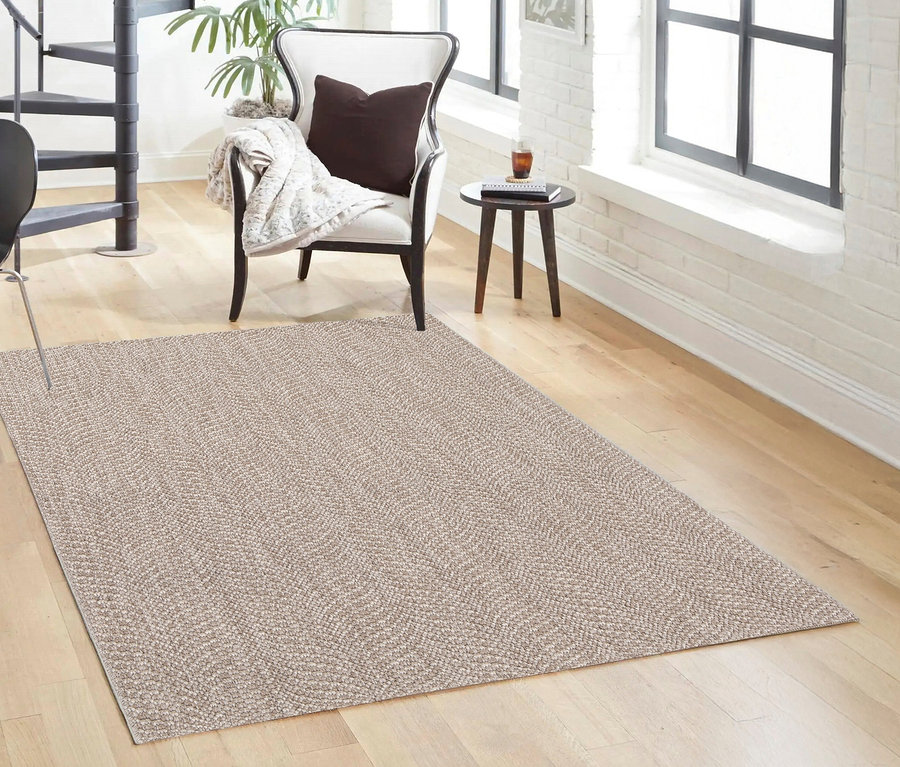 Ein Teppich »Twine« in Natural Flow liegt auf einem Holzboden im Wohnzimmer.