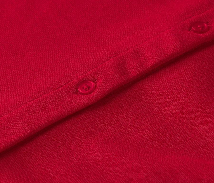 Detailaufnahme eines roten Kleidungsstücks mit Knöpfen.