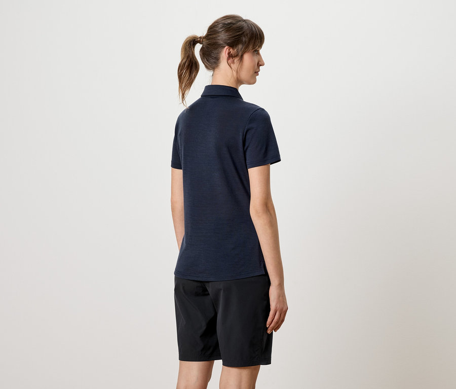 Frau von hinten, mit dunklem Poloshirt und schwarzen Shorts.