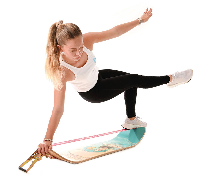 Junge Frau balanciert auf einem F2 Surfline Board Slackline.