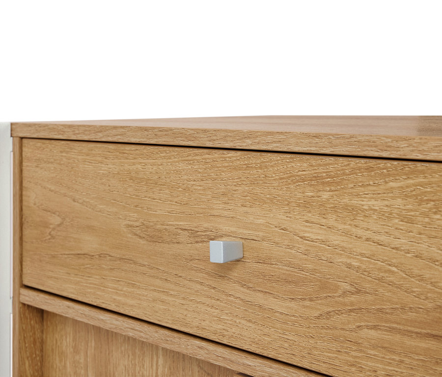 Nahaufnahme einer hellbraunen Holzkommode mit silbernem Griff.