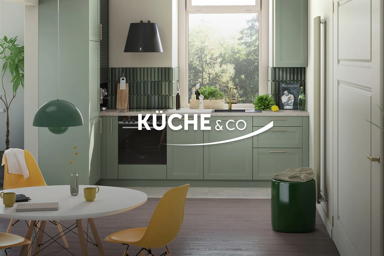 Grüne Küche mit Esstisch und gelben Stühlen unter einer grünen Hängelampe. Ein grüner Hocker steht neben einer weißen Tür.