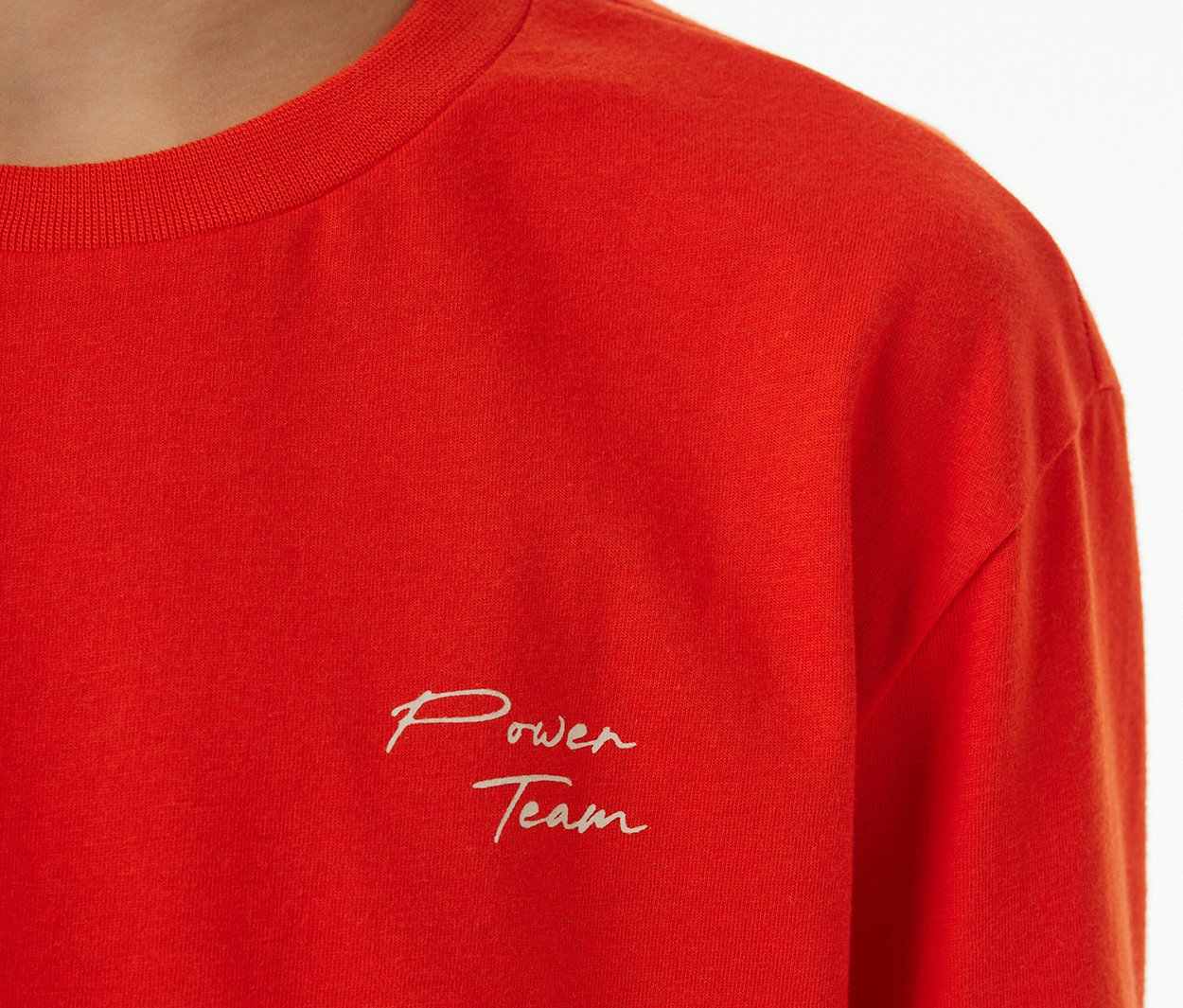 Rotes Kinder-Pyjama-Oberteil mit weißer "Power Team"-Stickerei auf der Brust.
