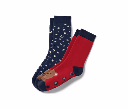 Zwei Paar Kinder-Antirutsch-Socken: ein Paar dunkelblau mit weißen Sternen und Monden, ein Paar rot mit Bär und Sternen.
