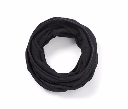Ein schwarzes Multifunktionstuch ist zu einem Kreis gerollt.