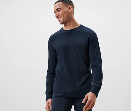Mann lächelt und trägt ein marineblaues Langarmshirt mit RWS-zertifizierter Wolle.
