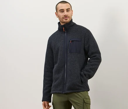Mann posiert in Thermo-Strickfleecejacke und olivfarbener Hose.