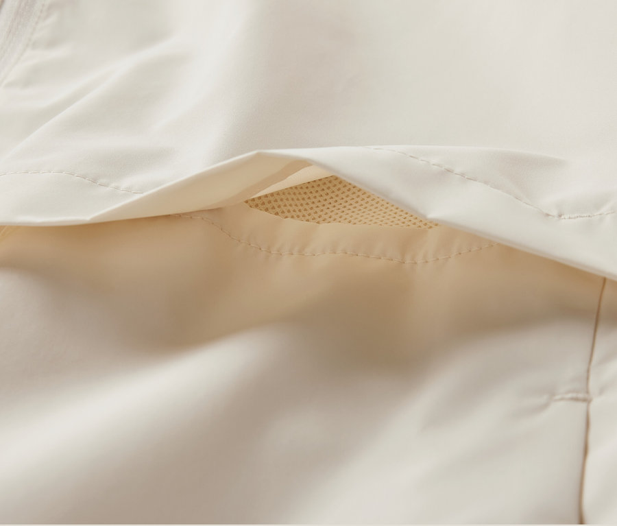 Detailansicht einer creme-farbenen Windprotection-Laufjacke.