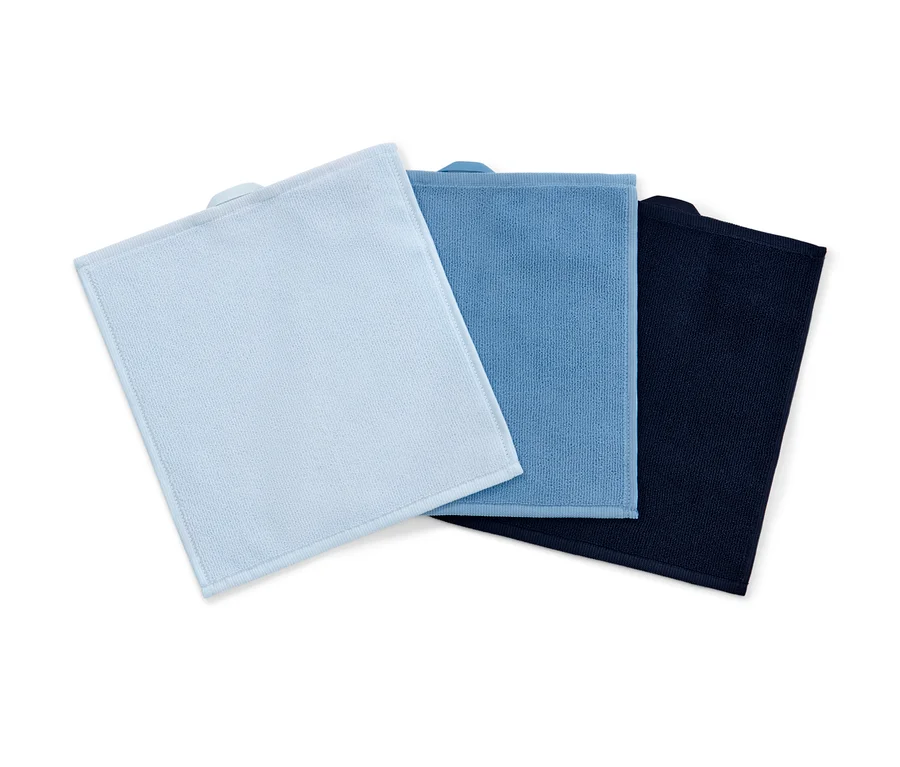 Drei blaue, hellblaue und dunkelblaue Kosmetiktücher aus Mikrofaser liegen übereinander.