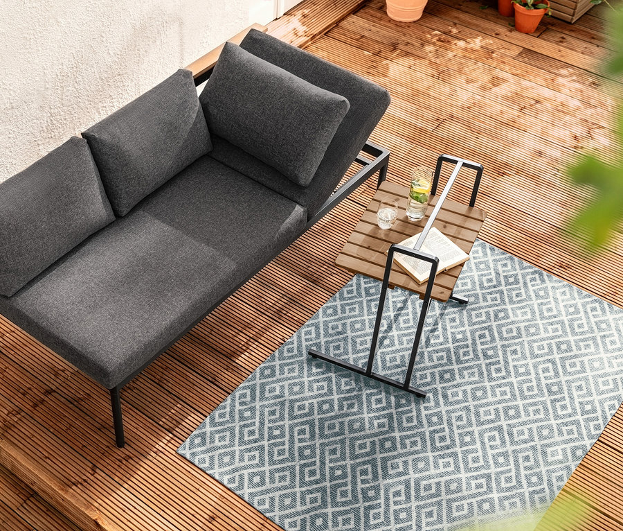 Draufsicht auf 2-in-1-Dining-Bank-Liege "Elin" neben C-Table mit großer Tischplatte auf Holzterrasse.