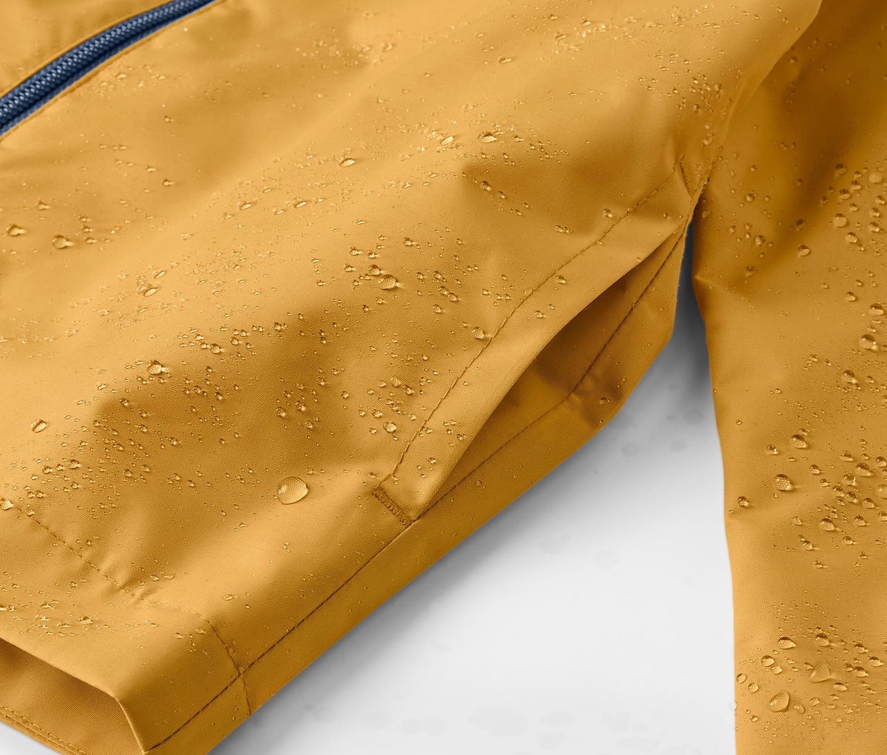Detailaufnahme einer gelben Kinder-Regenjacke mit Wassertropfen.