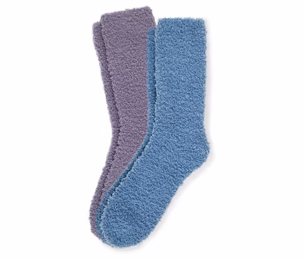 Nahaufnahme von zwei Paar flauschigen Socken, eines lila und eines blau, auf einem weißen Hintergrund.