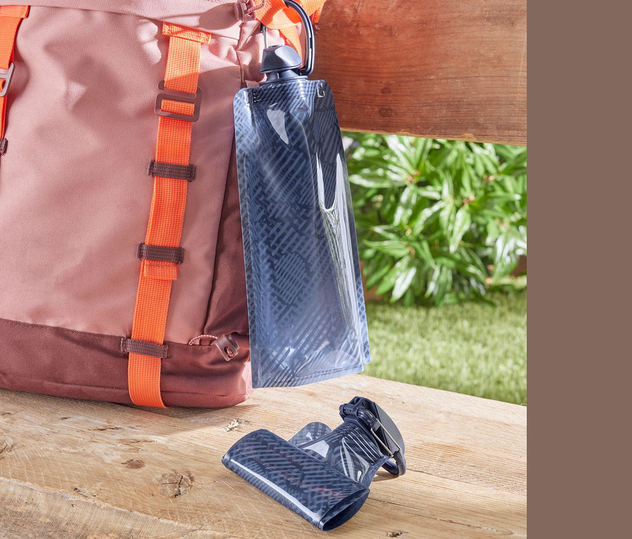 Ein rosa-brauner Rucksack mit orangefarbenen Trägern und zwei Trinkbeutel.