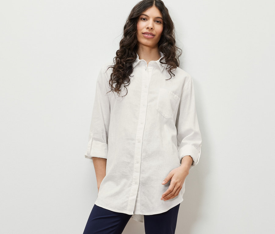 Frau posiert in langer Leinenbluse, weiß.