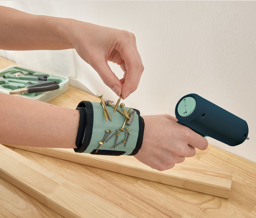 Eine Hand nimmt eine Schraube von einem Magnetarmband.