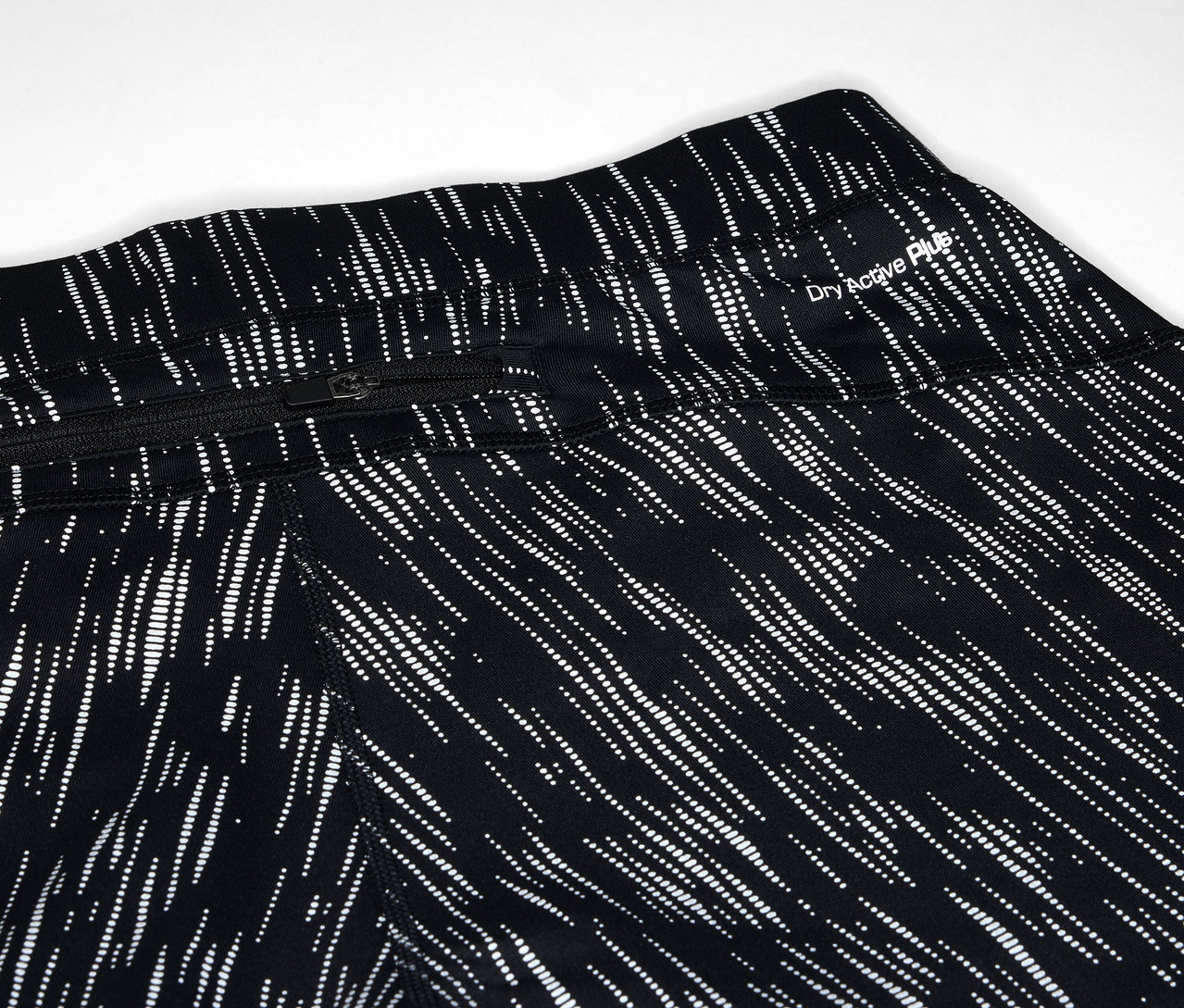 Detailaufnahme von schwarzen Leggings mit weißem Linienmuster und Reißverschlusstasche.