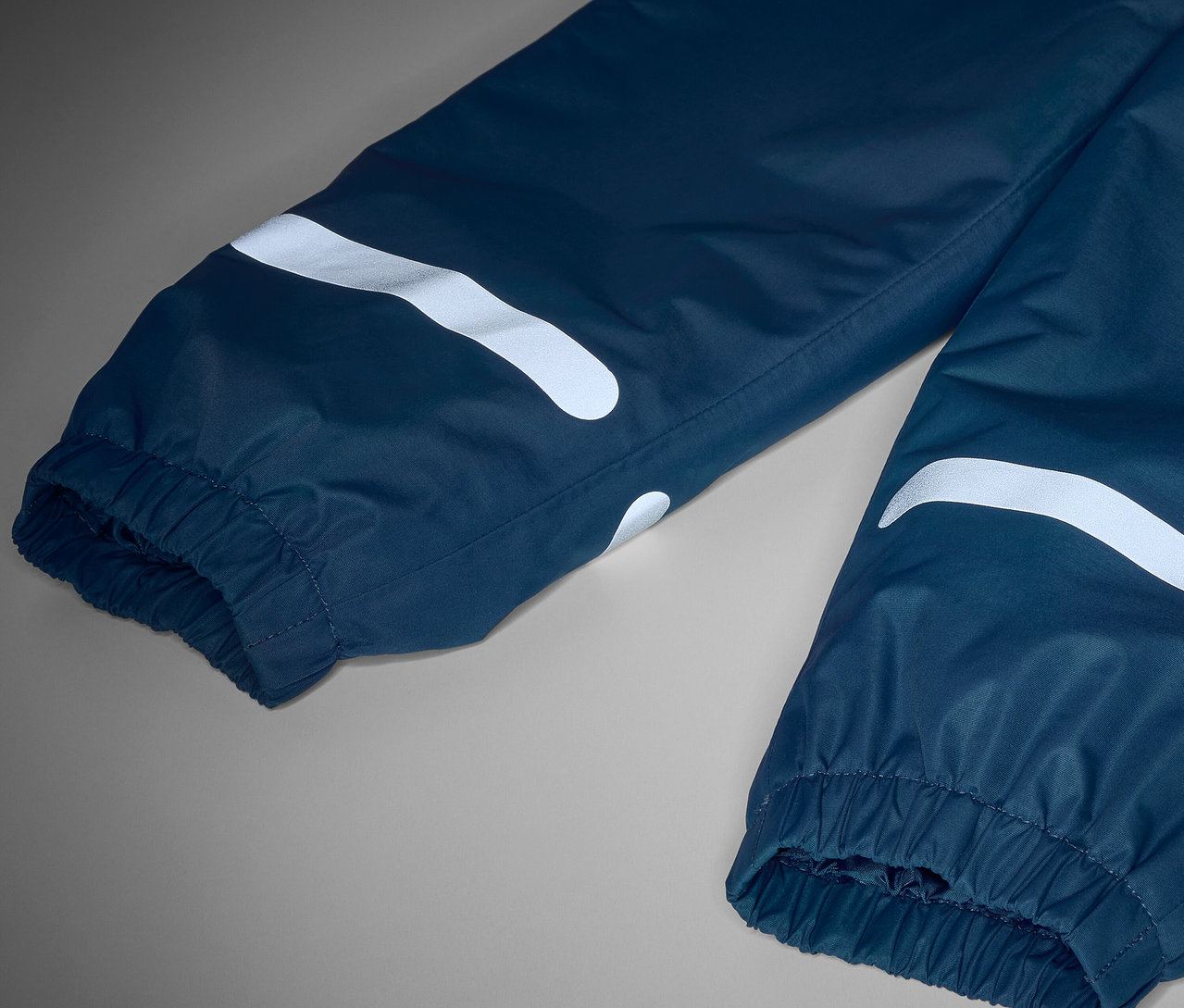 Detailaufnahme einer Kinder-Thermo-Regenhose mit Reflektoren.
