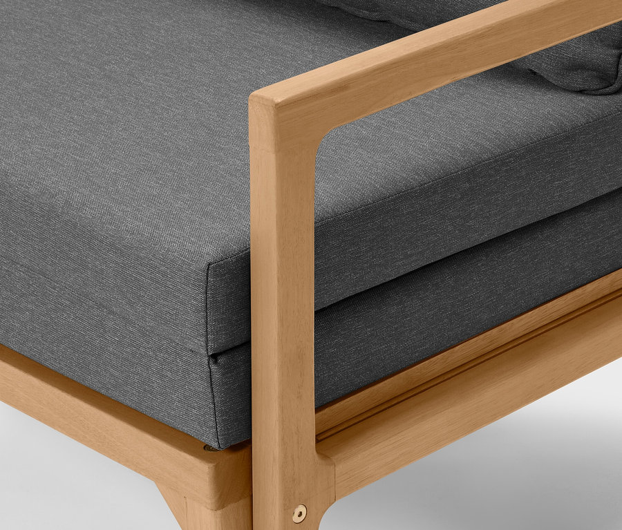 Detailansicht eines ausziehbaren Lounge-Sofas mit grauen Polstern und hellem Holzrahmen.