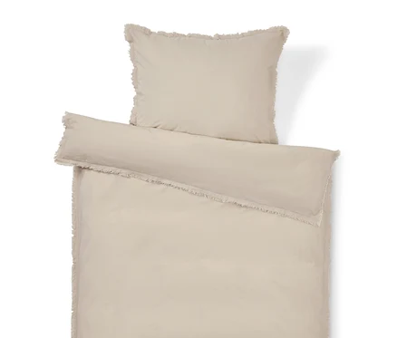 Beige Bettwäsche mit Fransen, bestehend aus einem Kissenbezug und einem Bettbezug.