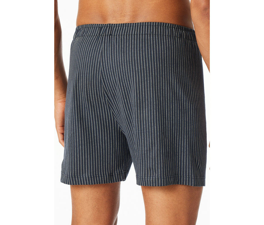Rückenansicht einer Person, die blaue SCHIESSER Jersey-Boxer mit feinen weißen Streifen trägt.