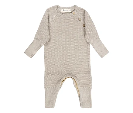 Beiger, gestrickter Baby-Strampler mit langen Ärmeln und Beinen, rundem Halsausschnitt und zwei Knöpfen an der Schulter.