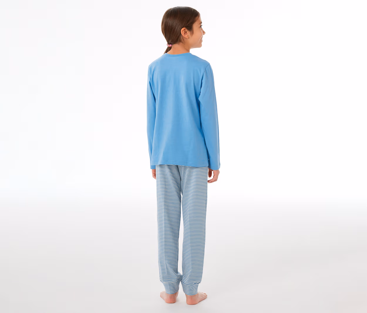 Mädchen von hinten, leicht nach rechts gedreht, trägt einen SCHIESSER Kinder-Pyjama mit blauem Langarmshirt und gestreiften Hosen.
