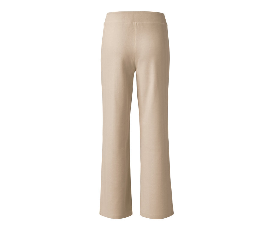 Eine beige Stretchhose auf weißem Hintergrund.