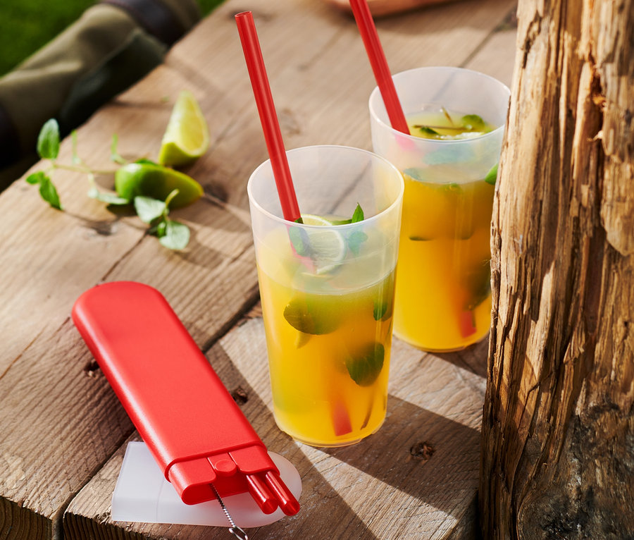Zwei Getränke mit roten Trinkhalmen und ein Set aus 4 Kunststoff-Trinkhalmen auf einem Holztisch.