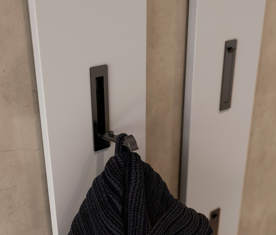 Ein schwarzer Strickpullover hängt an einem Haken an einem weißen Garderobenpaneel »Utah«.