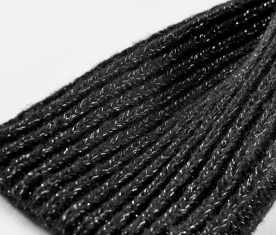 Detailaufnahme von glitzernden Strick-Handstulpen.