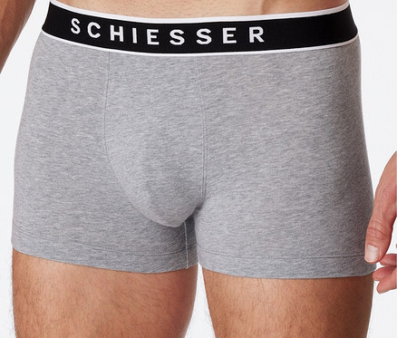 Mann posiert in meliert grauen 3 SCHIESSER Shorts mit Bio-Baumwolle.