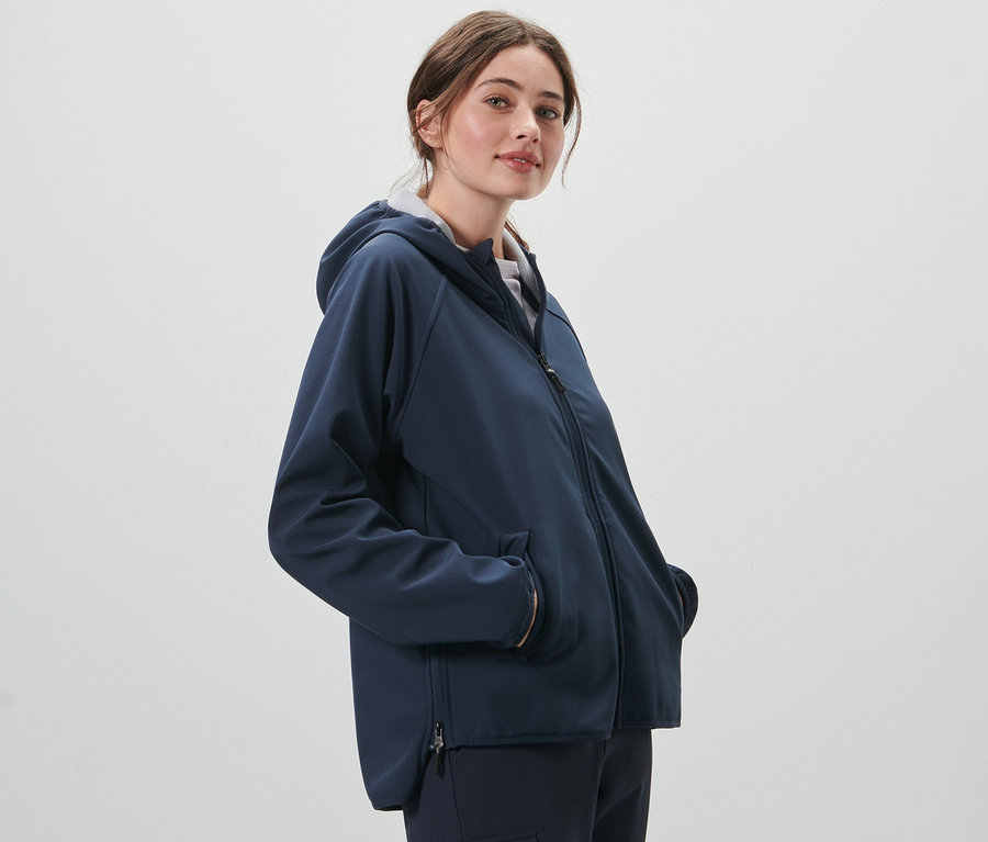 Frau posiert in einer Softshelljacke.