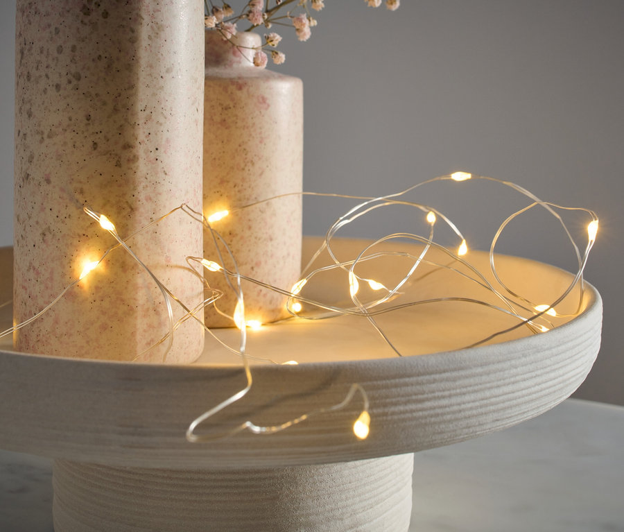 LED-Microlichterkette, Tropfen, liegt auf einem Dekotablett neben zwei Vasen.