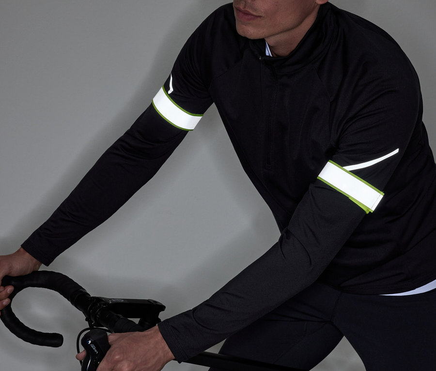 Mann in schwarzer Sportbekleidung fährt Fahrrad.