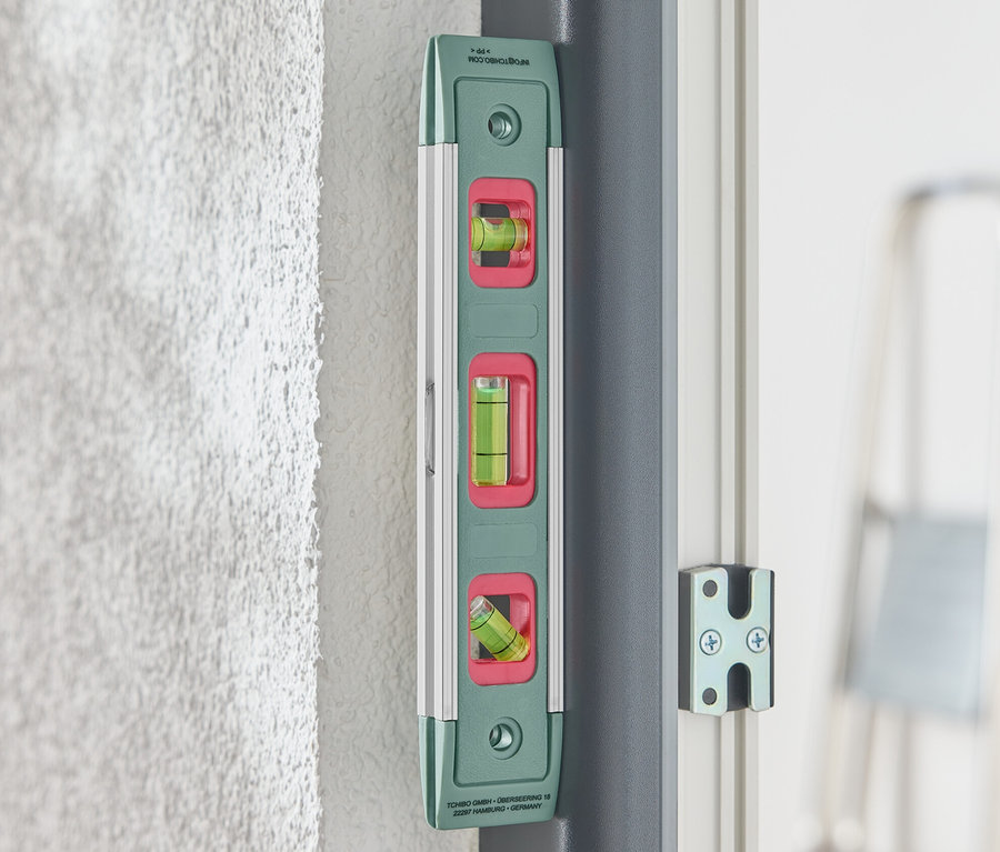 Eine grüne Magnet-Wasserwaage ist an einer Wand befestigt.